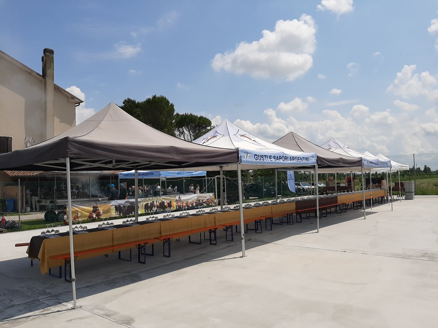 Lunghe tavolate apparecchiate sotto i gazebo Santa Fé Catering